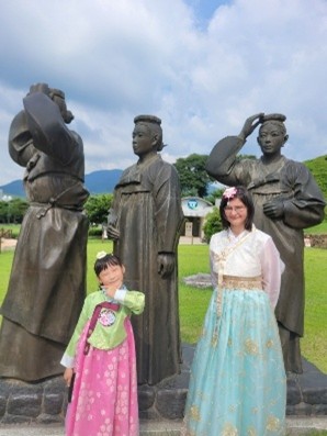 Two girls standing in front of Korean statues.